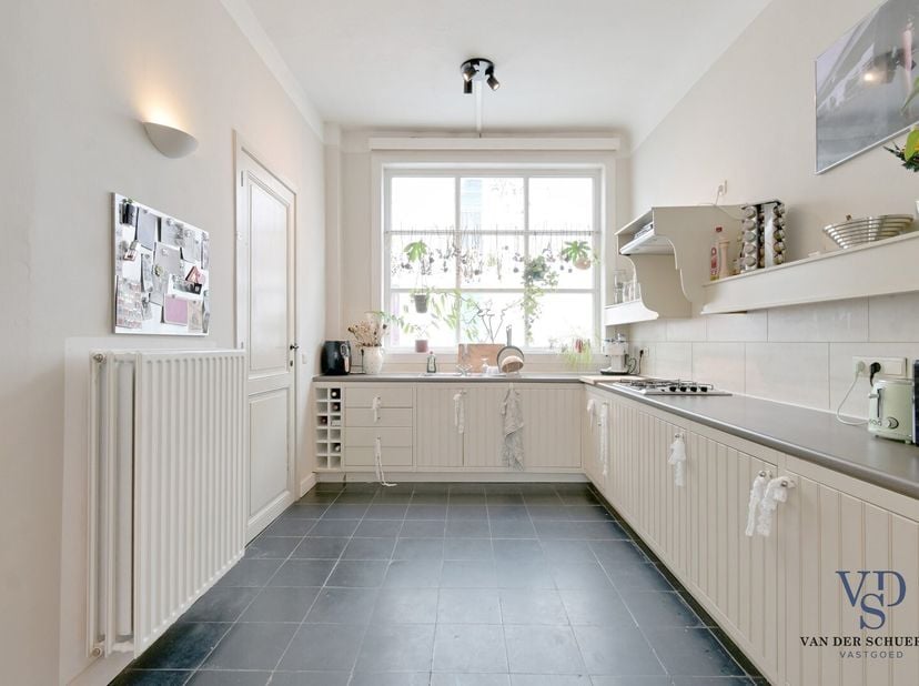 Het gelijkvloers omvat een inkomhal met gastentoilet en een ruime, eigentijdse keuken met eetplaats. Vanuit de keuken heb je toegang tot een knus priv