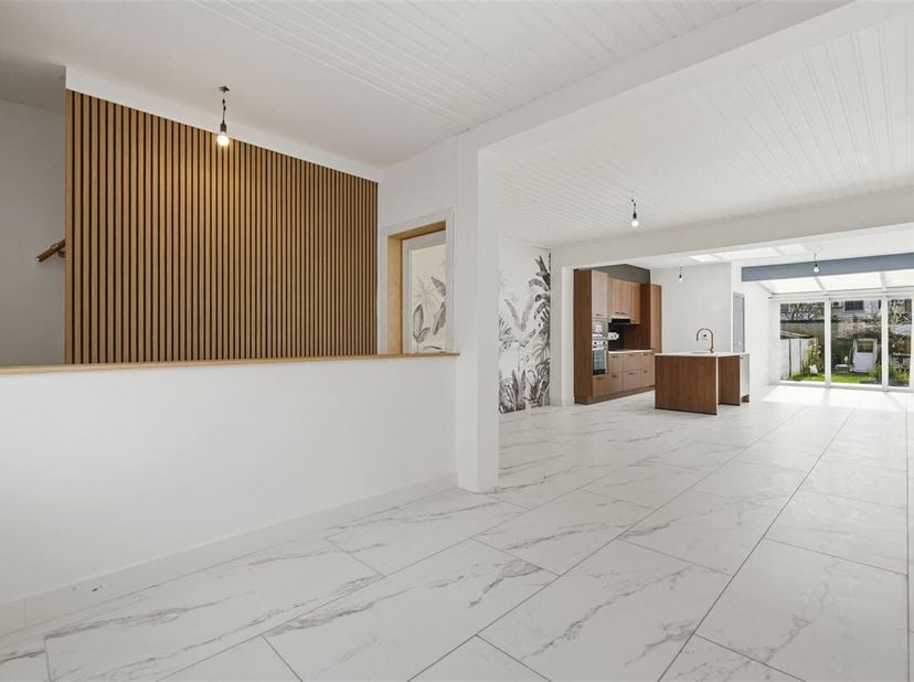 In een van de rustigste straten van Mechelen, ligt dit vernieuwde huis. De gevel met witte sierpleister is onderaan voorzien van een plint in blauwe h