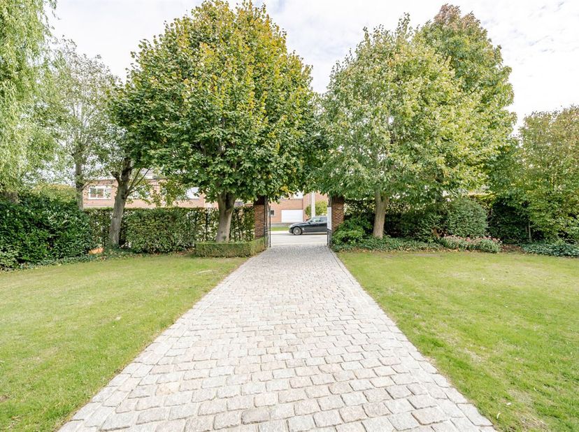Mooi gelegen, in het centrum van Aalbeke: charmante karaktervolle grote herenwoning met uitweg achteraan (3 garages). <br />
Indeling gelijkvloers: ru