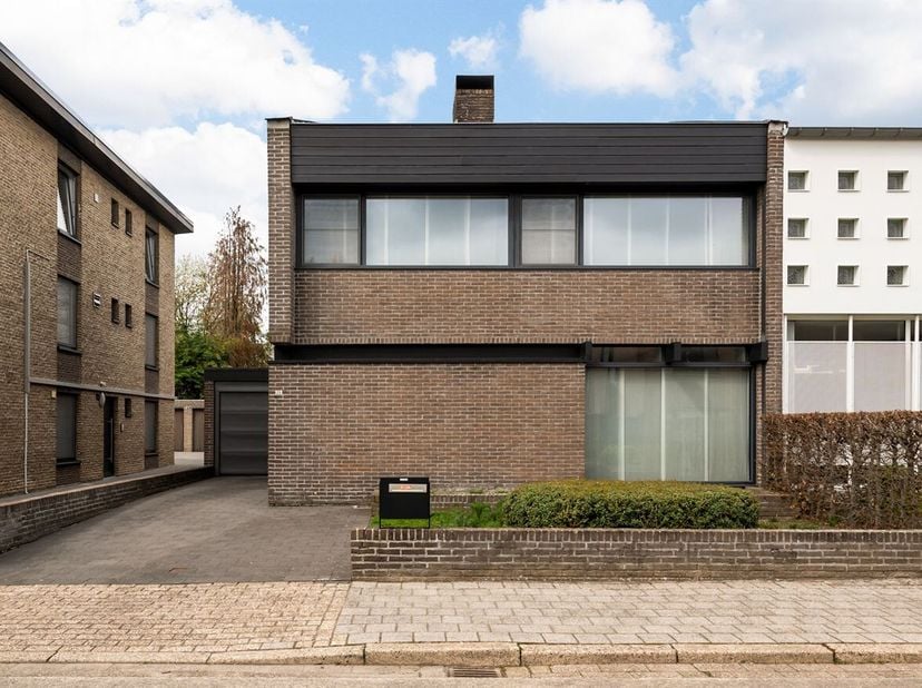 Gezinswoning met 3 slaapkamers, tuin en garage<br />
Gelijkvloers<br />
Via de inkomhal met ingemaakte kast en gastentoilet betreedt u de woning. De l