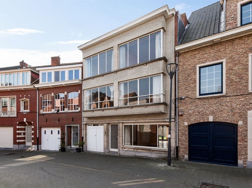 Ruime gezinswoning met 7 slaapkamers en zuidgerichte stadstuin<br />
Gelijkvloers<br />
Via de inkomhal met gastentoilet betreedt u de woning. De ruim