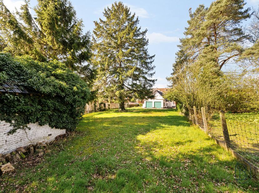 Charmante fermette à rénover avec POTENTIEL, 2 garages, allée et joli jardin avec four à pain authentique ! Cette maison de caractère (année de constr