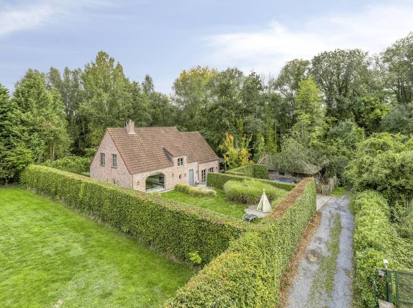 Binnen wordt u verwelkomd door een ruime, lichtrijke leefruimte met prachtige parketvloer en gezellige haard. De grote raampartijen zorgen voor een na