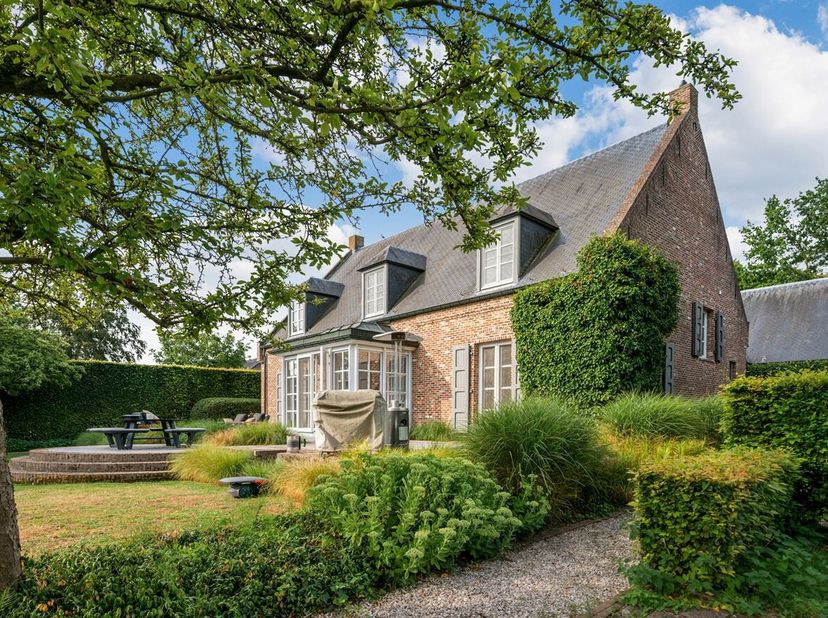 Deze stijlvolle villa in pastorijstijl is gelegen in een rustige, praktisch doodlopende straat en geniet achteraan van een blijvend vrij uitzicht over