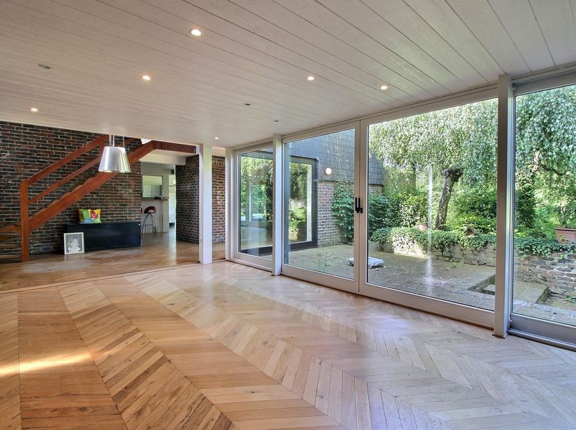 Belle maison aux volumes généreux située sur un terrain de ± 3.000 m², comprenant un hall d’entrée, un lumineux séjour avec cuisine ouverte, une salle