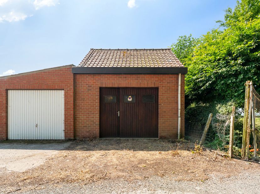 Deze op te frissen woning met ruime garage en uitweg is gelegen in de dorpskern van Watou.<br />
We betreden de woning langs de hal met aansluitend wo