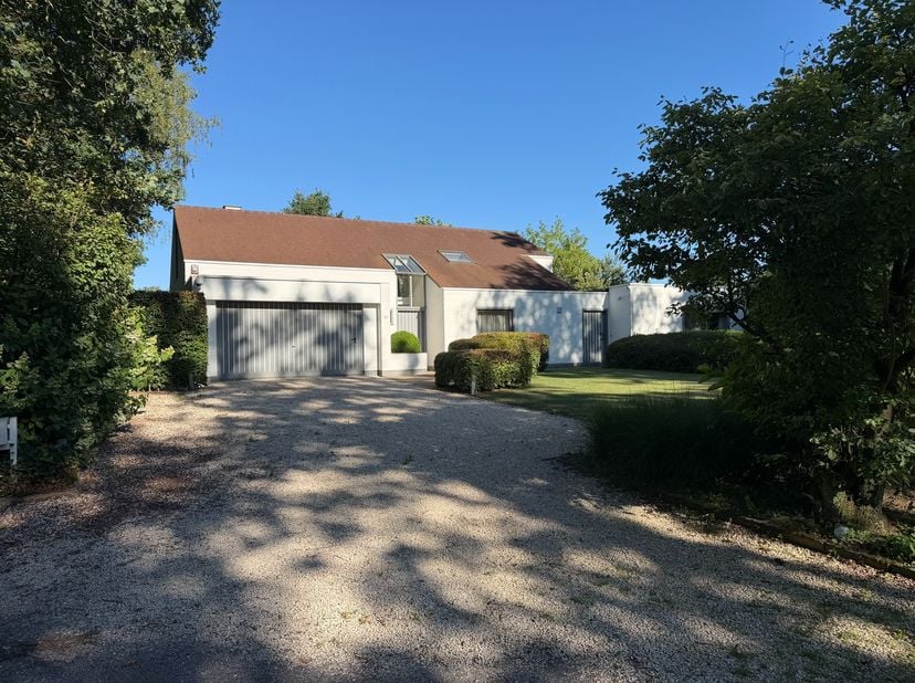 In de rustige, groene Eikenlaan in Belsele bevindt zich deze discreet ingeplante villa uit 1979 met een bewoonbare oppervlakte van 297 m² op een riant
