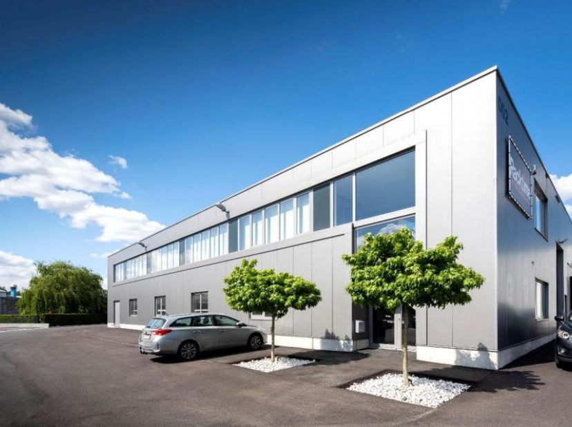 Bâtiment industriel à proximité de l’A12. Entrepôt avec 2 quais de chargement, 2 portes et un sol en béton poli d’une capacité de charge de 3 t/m². Bu