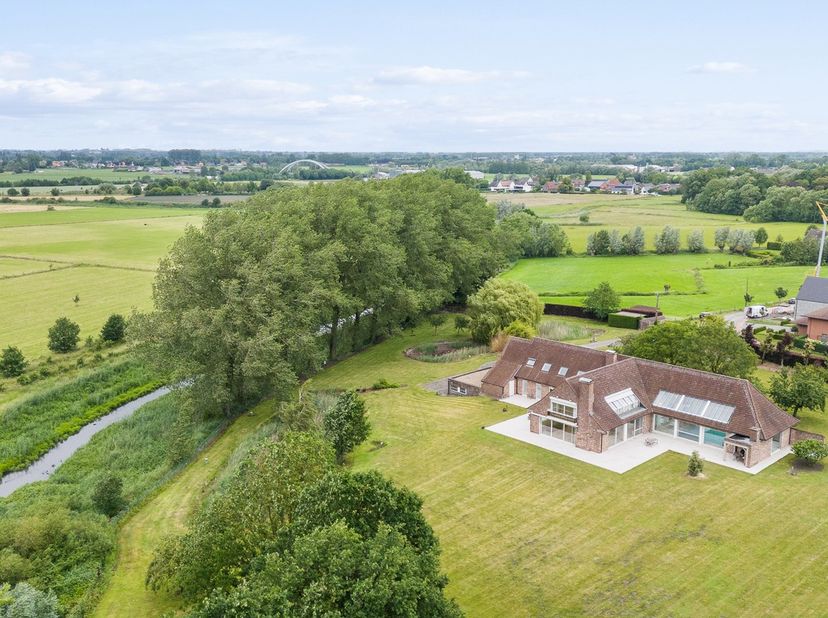 Omringd door weidse graslanden ligt deze imposante villa, een woning die rust en ruimte op een vanzelfsprekende manier met elkaar verzoent. Wie hier t