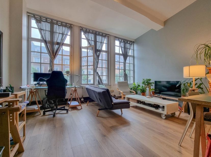 Ruim appartement met 2 slaapkamers van ongeveer 100 m².<br />
Grote hal, garderobe, aparte wc, woonkamer bestaande uit salon en eetkamer, nieuwe inge