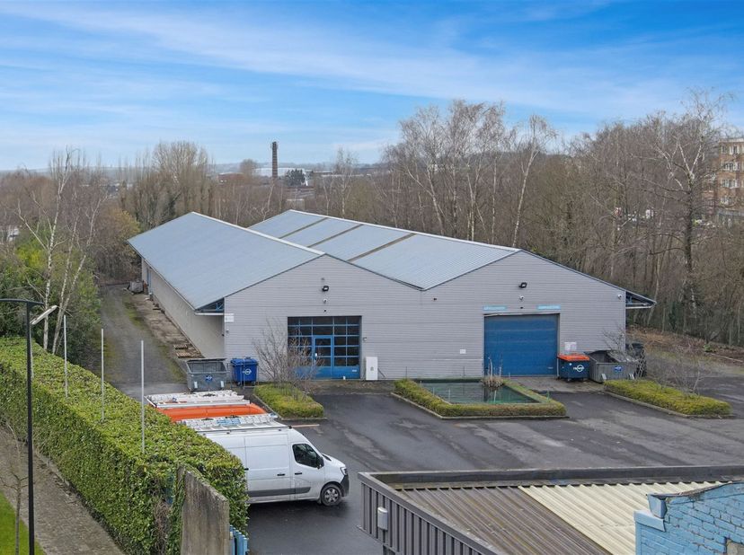Bâtiment commercial multifonctionnel d'environ 900 m², idéal pour stockage. Le bâtiment est accessible par une porte sectionnelle et dispose d'un bure