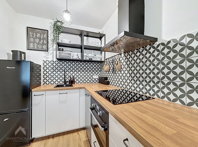 Welkom in dit stijlvol volledig gerenoveerde gelijkvloerse appartement, waar hedendaags wonen en comfort hand in hand gaan. De inkomhal leidt naar een