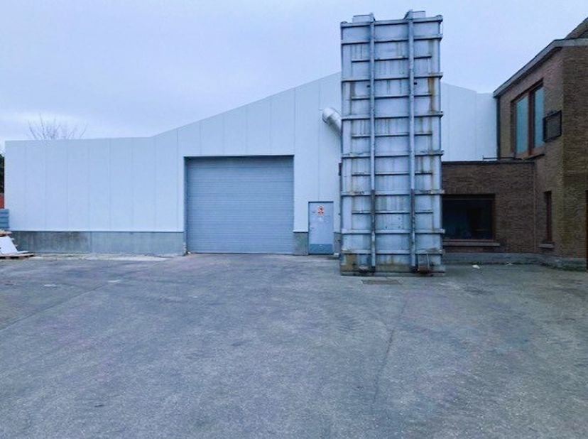 Indeling: Magazijn : 1500m² Bureel: 56m² wc keukentje Faciliteiten: vernieuwde betonvloer groot plein om te laden en te lossen vooraan magazijn weegbr