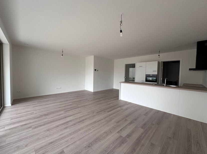 Ruim gelijkvloers nieuwbouwappartement met autostaanplaats!<br />
<br />
Indeling: <br />
Inkomhal, leefruimte met open keuken, berging, terras, to