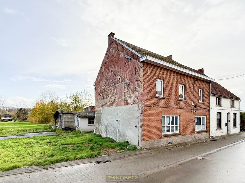Maison entièrement à rénover avec une superficie habitable étonnamment grande de 220 m², un jardin profond et une magnifique vue dégagée dans le cadre