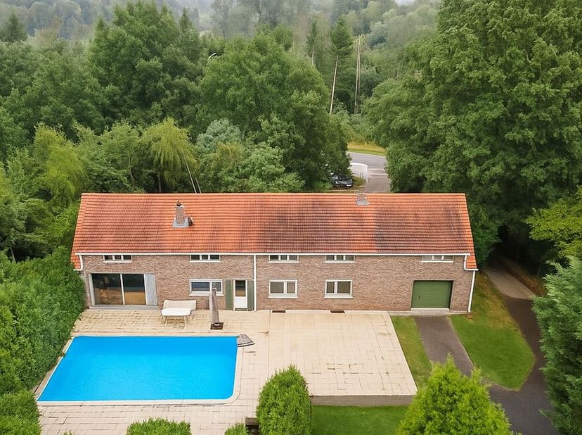 Te midden van een prachtig bosrijk gebied, omringd door groen en natuur, bevindt zich deze uitzonderlijke woning met een totale bewoonbare oppervlakte