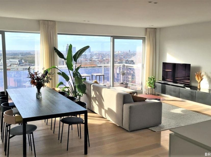 Dit penthouse heeft werkelijk alles in huis. De ruime woonkamer met open keuken biedt een panoramisch uitzicht over de stad. Dankzij de grote raampart