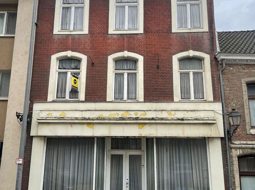 Rijwoning, ideaal gelegen te Wolmarkt 7 in Tienen. Via de gelijkvloers komen we binnen in een polyvalente, grote ruimte die kan dienen als extra leefr