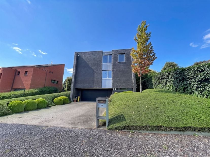 Op de gelijkvloerse verdieping is er een inkomhal (12m²), een afgezonderde bureauruimte (23m²) of gastenkamer en een ruime garage (65m²) voor 4 wagens