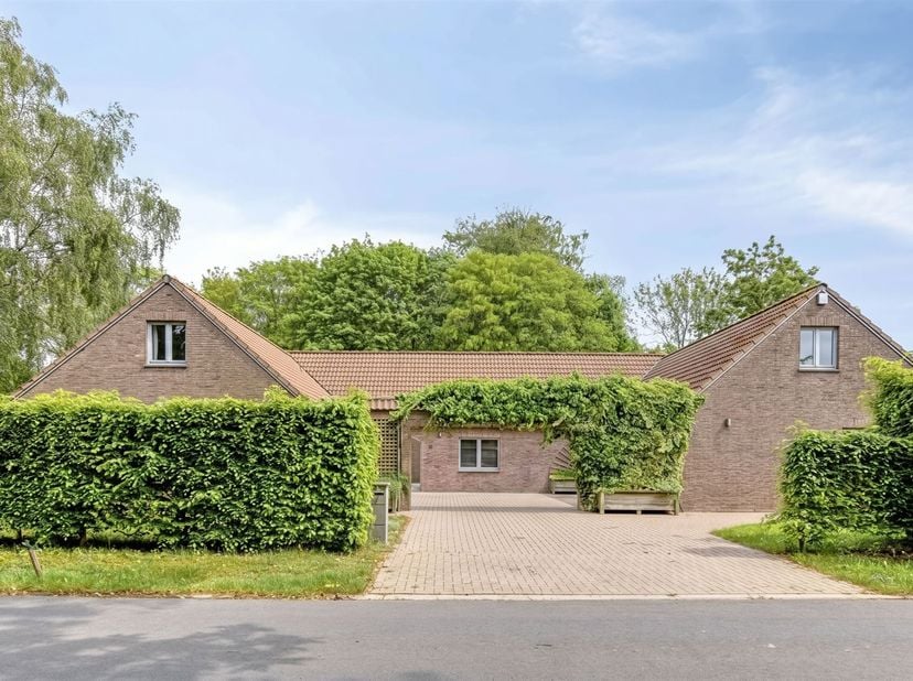 Deze ruime en goed onderhouden woning is gebouwd in 1989. Op het gelijkvloers vindt u een inkomhal met gastentoilet, een ruime lichtrijke woonkamer en