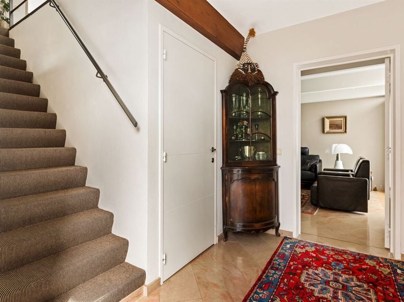 Gezinswoning met 3 slaapkamers, tuin en garage<br />
Gelijkvloers<br />
Via de inkomhal met ingemaakte kast en gastentoilet betreedt u de woning. De l
