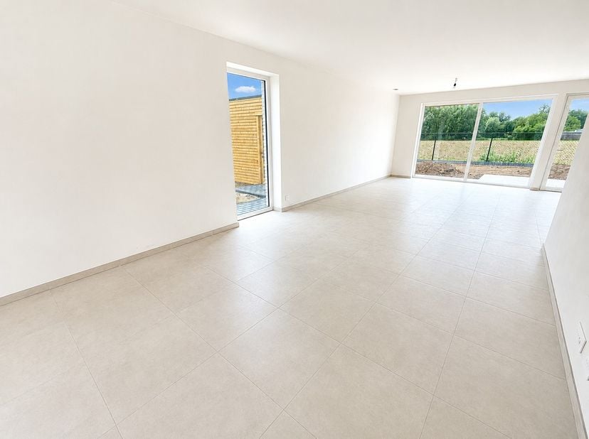 Langs de Roeselarebaan in Lichtervelde, treffen we een halfopen nieuwbouwwoning. Deze woning omvat een inkomhal met gastentoilet. Ruime leefruimte met