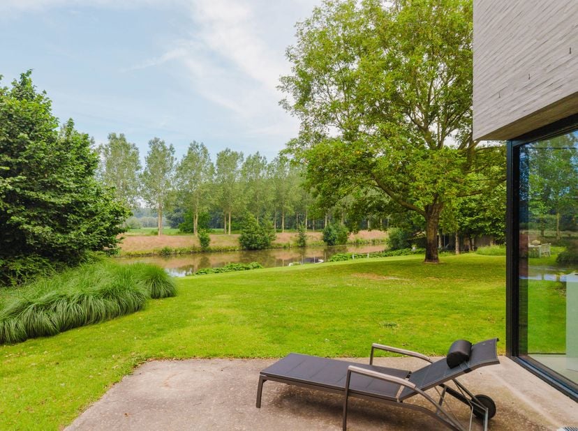 Ligging<br />
Deze uitzonderlijke villa bevindt zich op een prachtige locatie in Astene, waar rust, natuur en architectuur perfect samenkomen. De woni