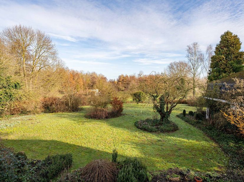 Deze karaktervolle kasteelvilla, ontworpen door architect C. Bogaerts en gebouwd in 1976, is gelegen op een uitzonderlijk groen en discreet domein in