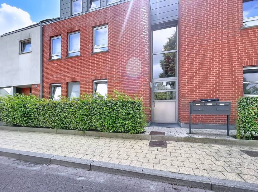 Het appartement op de eerste verdieping is voorzien van een ruime inkomhal, badkamer, 2 slaapkamers, woonkamer met keuken, berging, terras, kelderberg