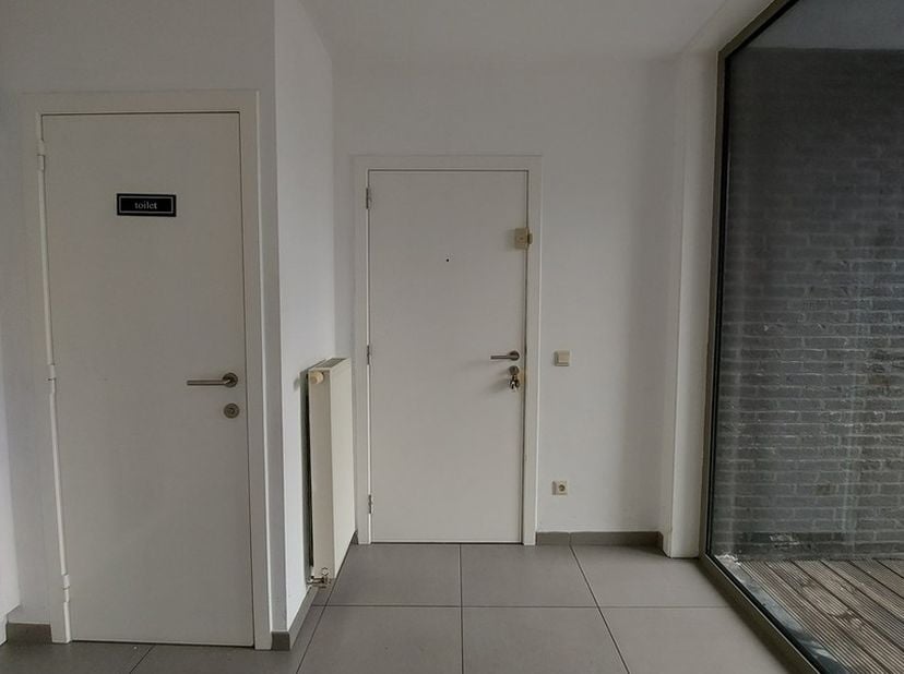 Zeer centraal gelegen modern appartement: inkom met vestiaire en toilet, ruime living, open keuken, berging/wasplaats, badkamer ligbad, aparte douchek