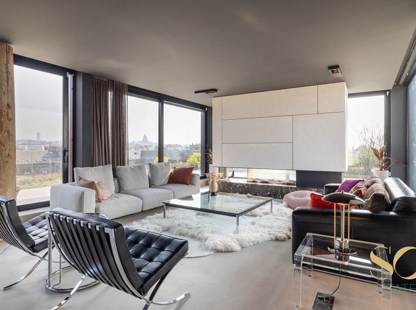 Situé dans le quartier Dansaert, face au canal, au 5ème étage d'un immeuble de 2014, ce penthouse duplex signé par l'architecte Glenn Sesstig offre un
