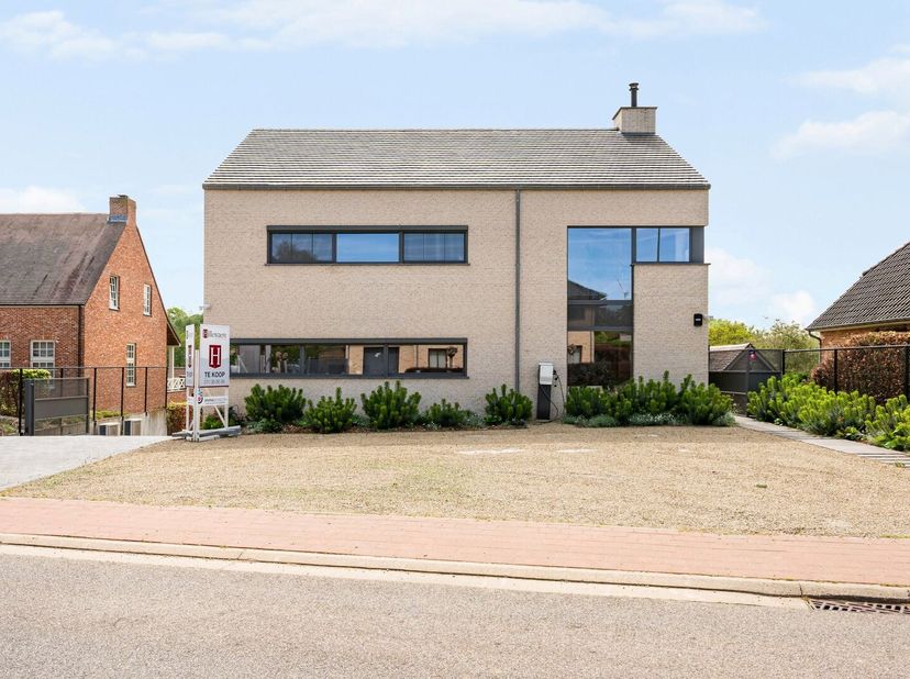 Op een perceel van maar liefst 3.947 m² bevindt zich deze hoogwaardige, moderne recente woning die ruimte, privacy en kwaliteit perfect combineert. Me