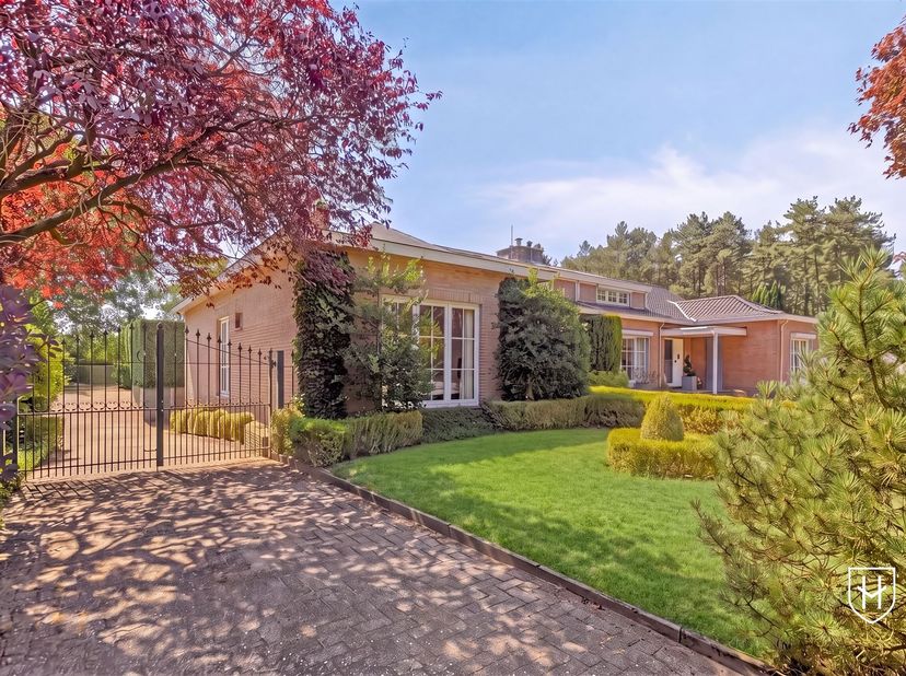 Aan de grens van Lanaken en Zutendaal, in een verkeersluwe straat aan de bosrand, bevindt zich deze verrassend royale bungalow op een prachtig zuidoos