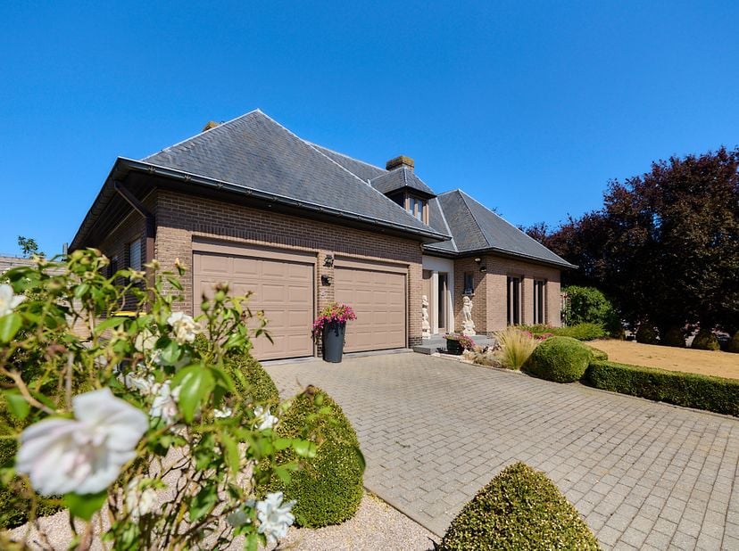 Reeds één voet op de oprit, en je merkt al overduidelijk het statige karakter van deze alleenstaande villa. Gebouwd eind de jaren 80, mocht deze indru