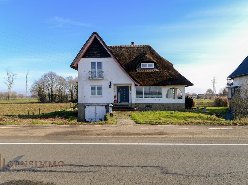 Langs de Rijksweg te Maasmechelen bevindt zich deze charmante vrijstaande woning met een uniek rieten dak en een landelijke uitstraling. De woning gen