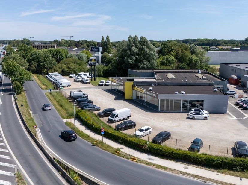 Op een volledig omheind terrein van 6.613 m² bevindt zich dit uitstekend gelegen bedrijfsgebouw met een uitzonderlijke zichtlocatie langs de E40, pal