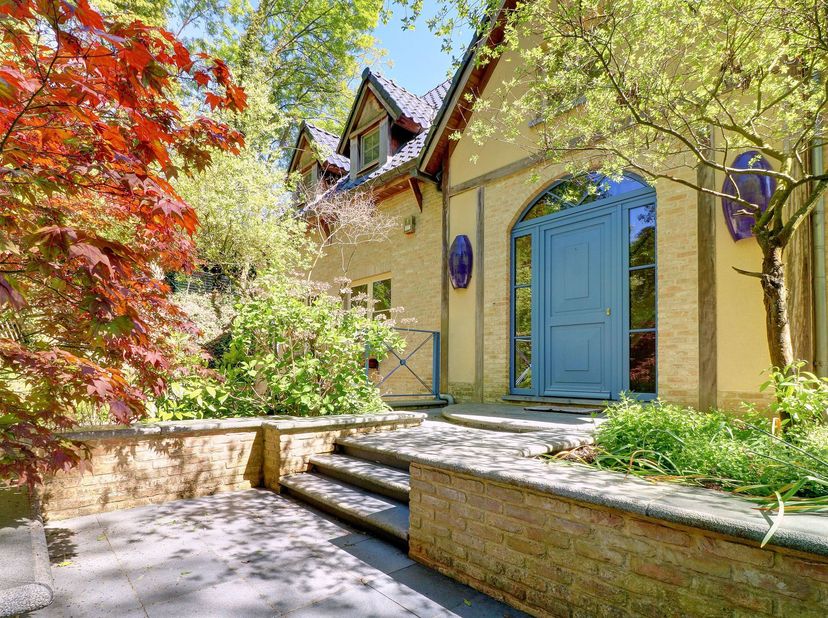 Schitterende eigentijdse villa (+- 350m² bewoonbare oppervlakte) :<br />
Begane grond : een betegelde hal + garderobe, wc en trap naar de eerste verdi