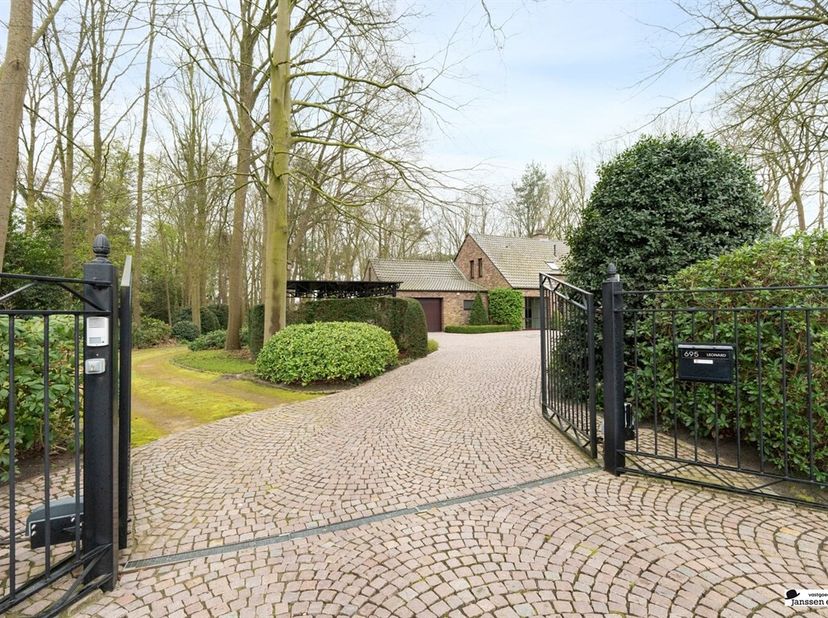 Située au centre, cette villa spacieuse offre un espace de vie lumineux avec une cheminée à gaz et de grandes fenêtres donnant sur le jardin. La cuisi