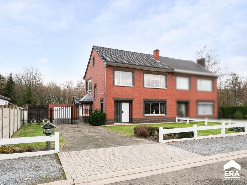 À vendre : agréable maison semi-ouverte située Rooierheidestraat à Diepenbeek, dans une rue calme au cadre verdoyant. Construite en 1967, cette habita