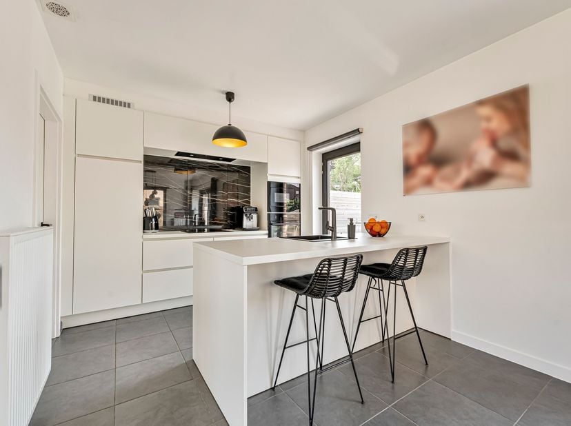 Energiezuinige halfopen bebouwing te koop in Menen<br />
Je betreedt de woning via de inkomhal met gastentoilet en komt vervolgens in de lichtrijke le