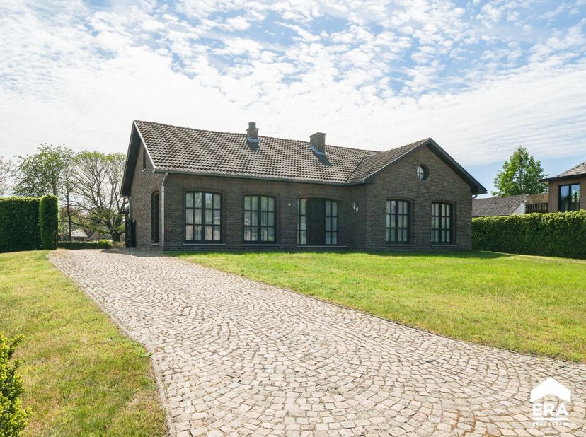Gelijkvloerse woning met ruime tuin op wandelafstand van centrum Zonhoven. Deze charmante woning uit 1975 is gelegen op een ruim perceel van ca. 22 ar