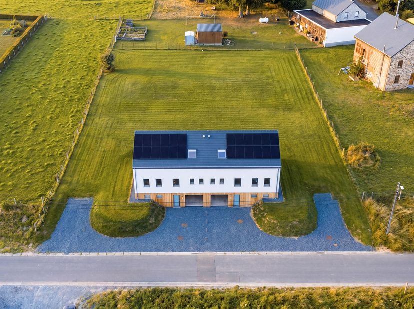 Op enkele minuten van Bastogne, in het hart van Saint-Ode, verenigt dit recente vastgoedcomplex twee geschakelde huizen met elk ongeveer 180 m² woonop