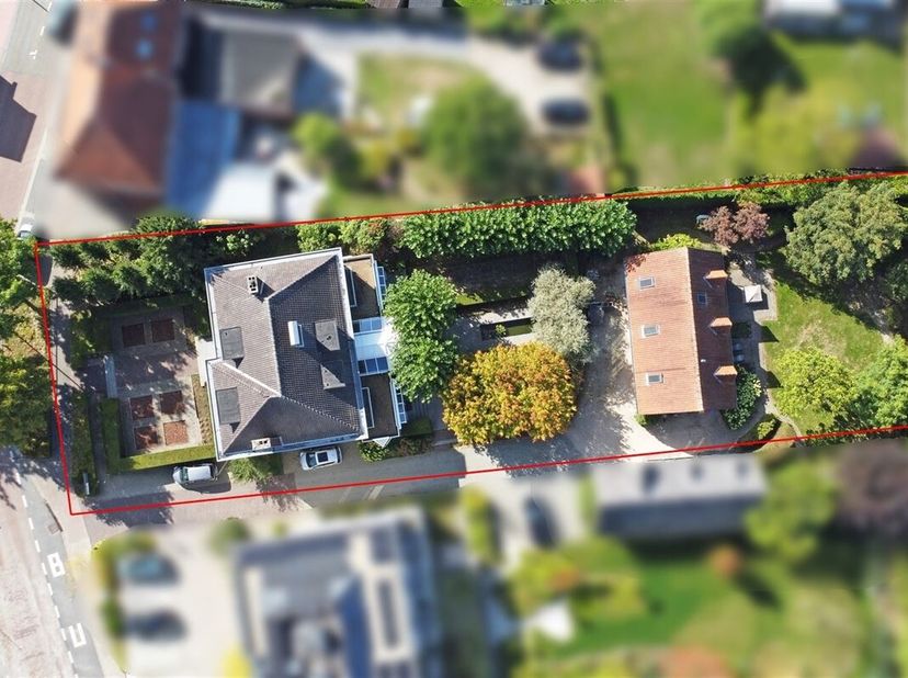 Via de inkomhal met gastentoilet betreden we enerzijds het leefgedeelte met een L-vormige woonkamer en eetkamer waar een open haard voor extra gezelli
