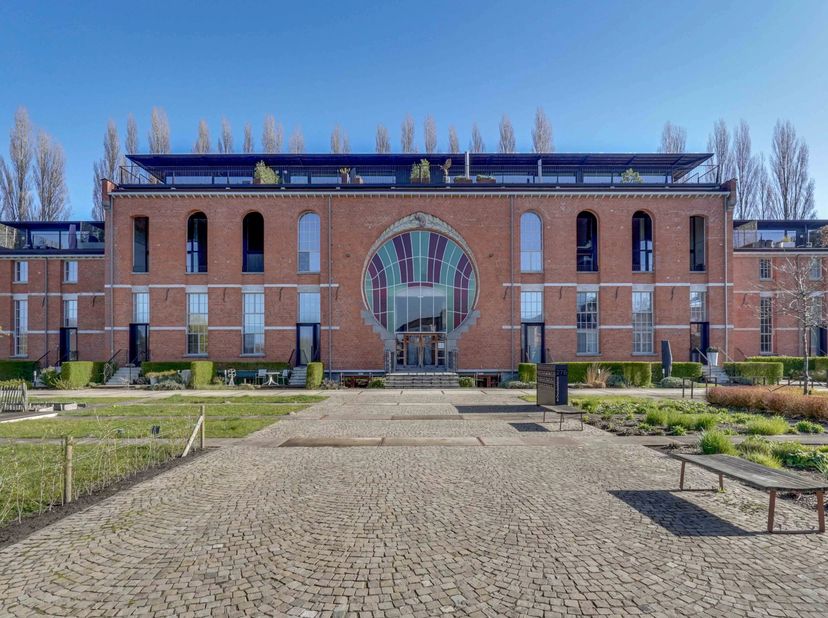 Dit penthouse met een ondergrondse parking en kelderberging bevindt zich in een karaktervol gebouw dat vroeger dienst deed als chocoladefabriek en met