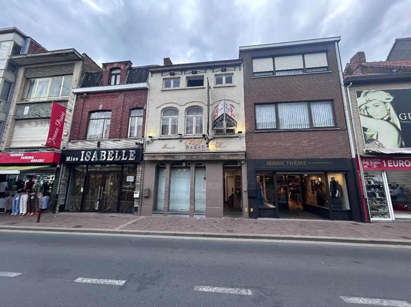 handelspand met ruime woonst en uitweg achteraanIndeling:gelijkvloers: ruime winkelruimte met extra keuken, tuin en 4 garageboxen met uitweg achteraan