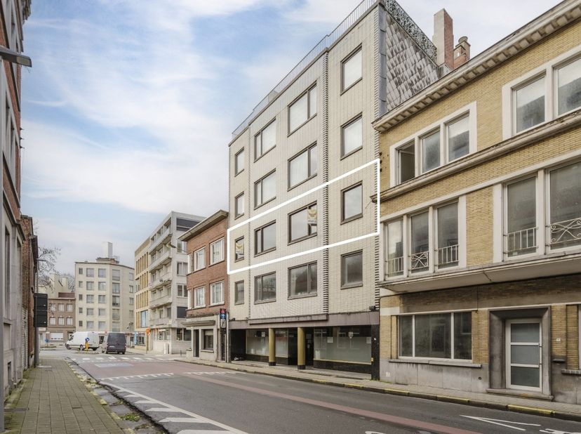 In het hart van Kortrijk, pal in het centrum en op slechts enkele meters van de Grote Markt, bevindt zich dit uitzonderlijk ruime appartement met een