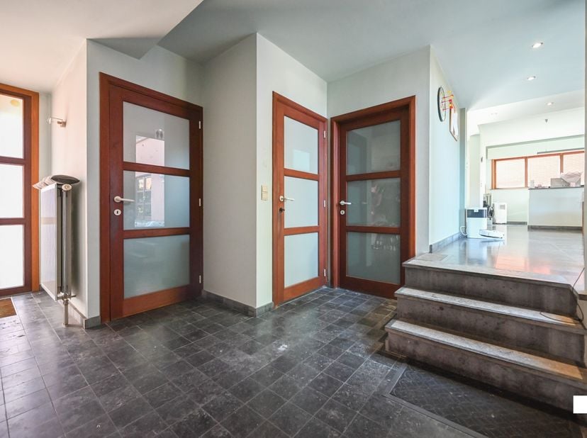 Deze aantrekkelijk gelegen, zeer ruime eengezinswoning met vijf slaapkamers en polyvalente ruimtes, is gelegen op een perceel van 1068 m² en beschikt