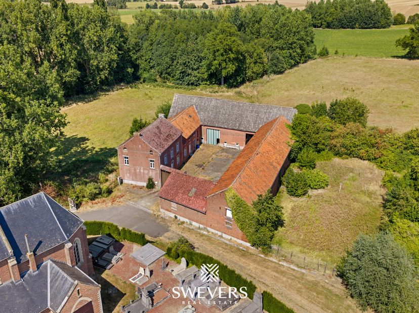 Voor meer info en foto’s, surf naar www.swevers.be – Deze karaktervolle, te renoveren vierkantshoeve uit 1935 aan Pastorijstraat 2 in Gingelom biedt e