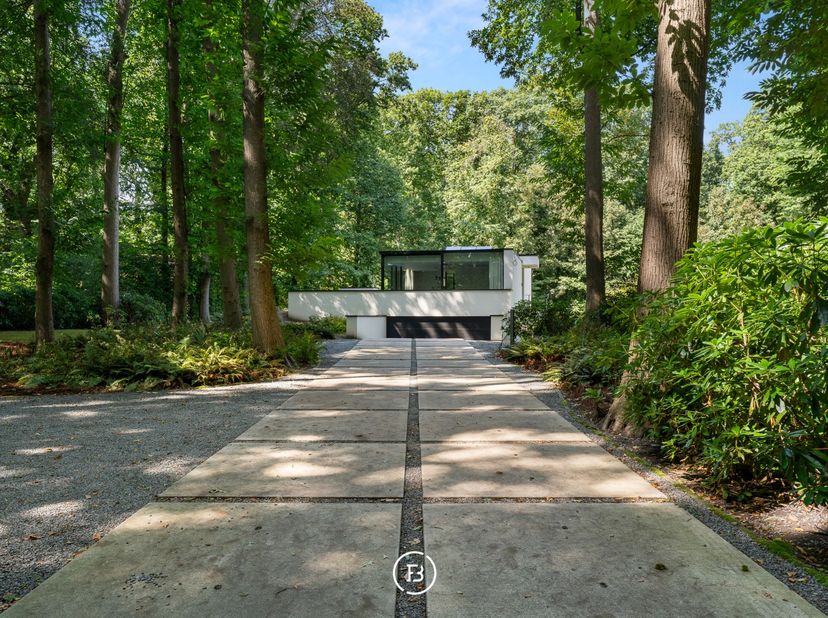 Deze moderne villa uit 2018 is discreet gelegen op een mooi perceel van 2.461 m². De woning en tuin liggen dieper op het perceel, bereikbaar via een l