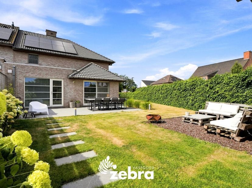 Deze recente en energiezuinige (EPC-label A) halfopen bebouwing met 3 slaapkamers en praktijk- of bureauruimte bevindt zich in een rustige woonwijk te